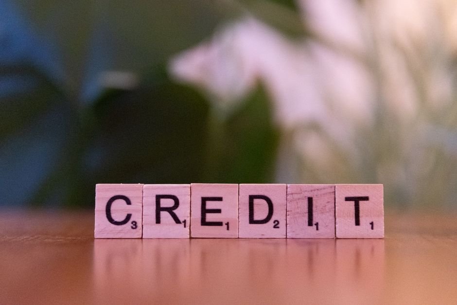 Scrabble tiles spelling CREDIT on a wooden table, representing improving your credit score for a UAE mortgage