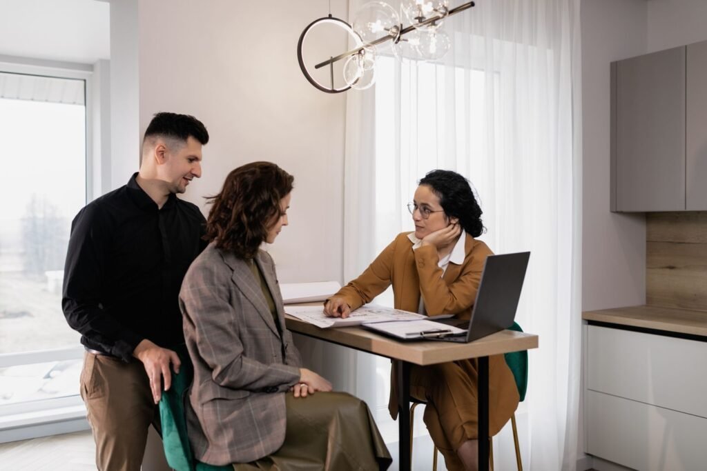 A couple consulting with a mortgage or real estate advisor over property documents about a joint home purchase