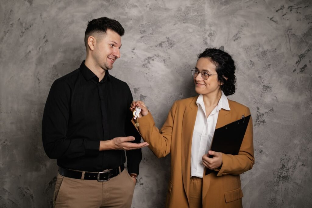 Real estate agent handing over house keys to a buyer after mortgage approval in the UAE