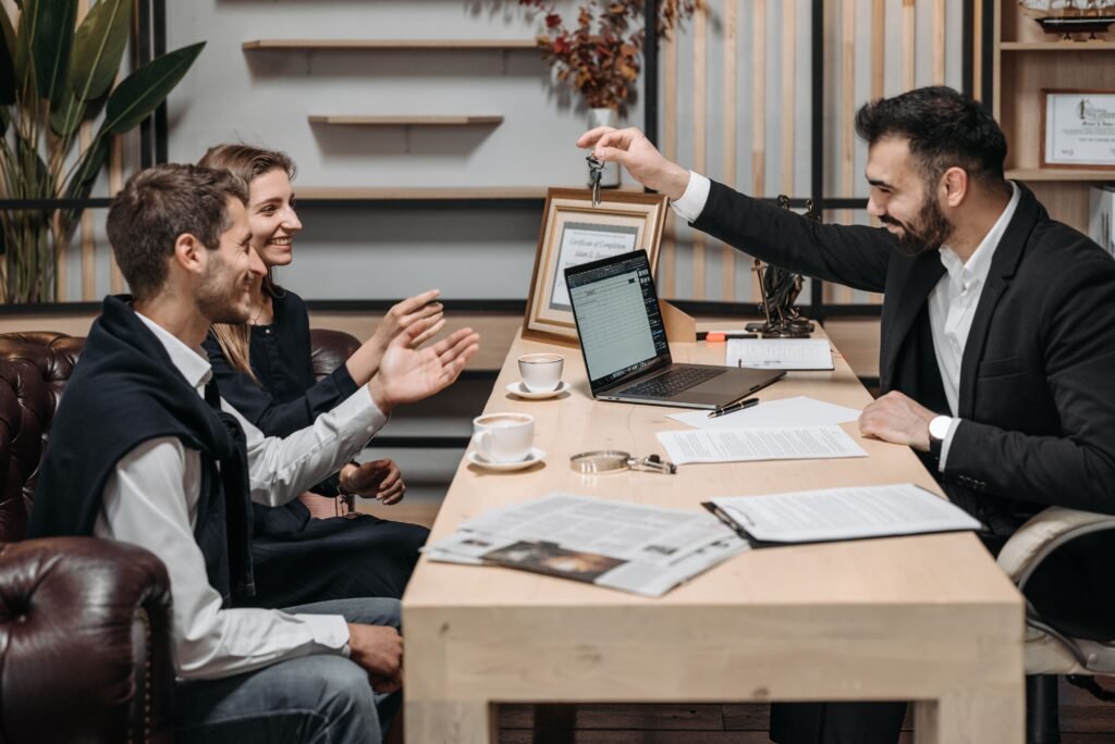 Mortgage consultant handing over keys to a couple after closing on a Dubai property purchase