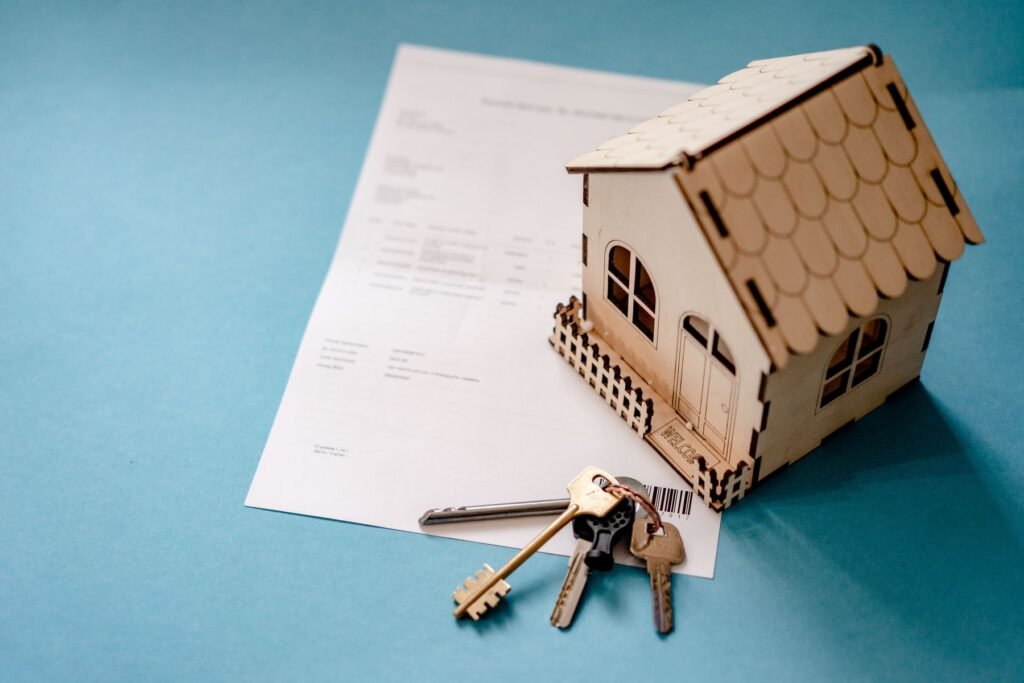 Wooden model house with keys resting on a mortgage document, representing UAE mortgage down payment and closing costs