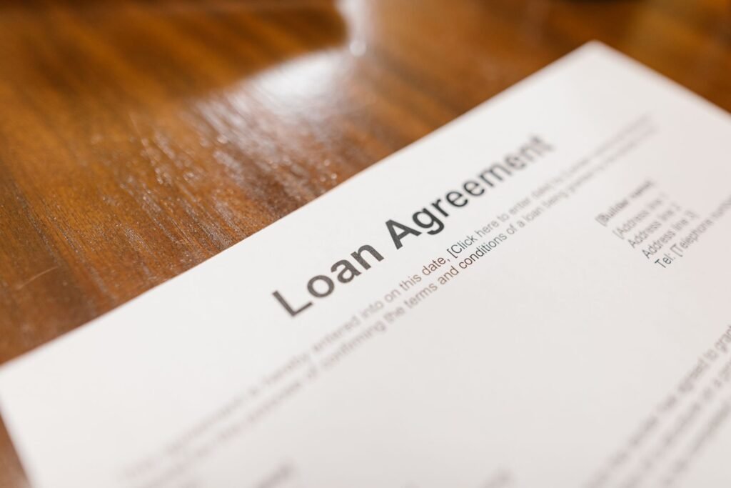 Close-up of a signed loan agreement document on a wooden table, representing early mortgage settlement paperwork