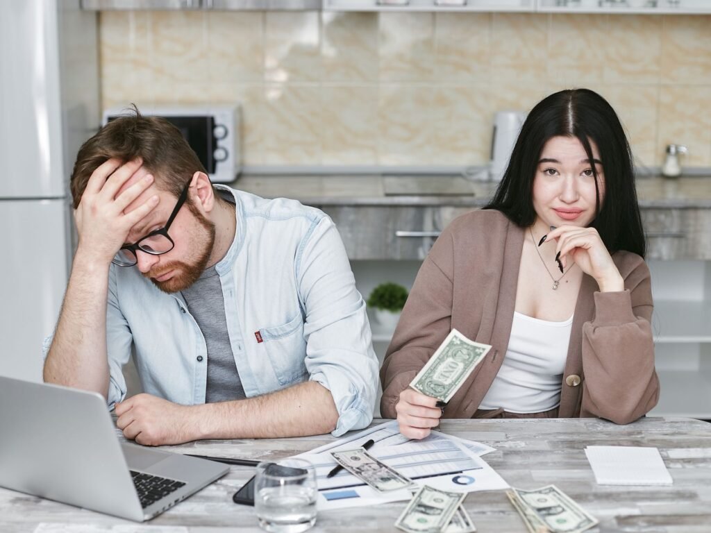 Stressed couple reviewing mortgage bills and financial paperwork together at home in the UAE