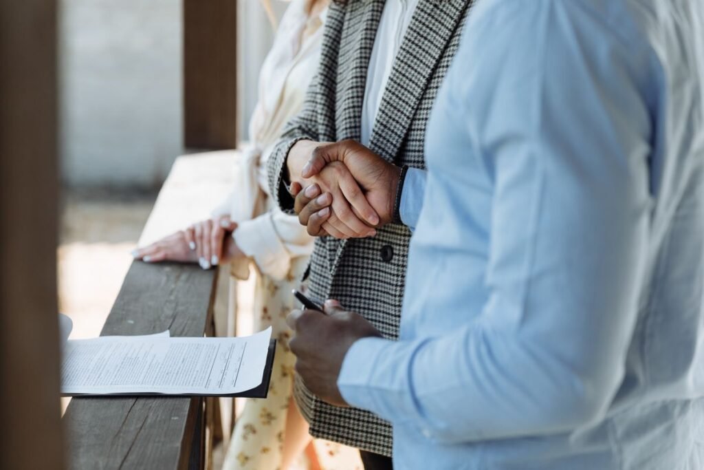Mortgage broker and client shaking hands over a signed agreement, representing broker commission and fee disclosure in Dubai