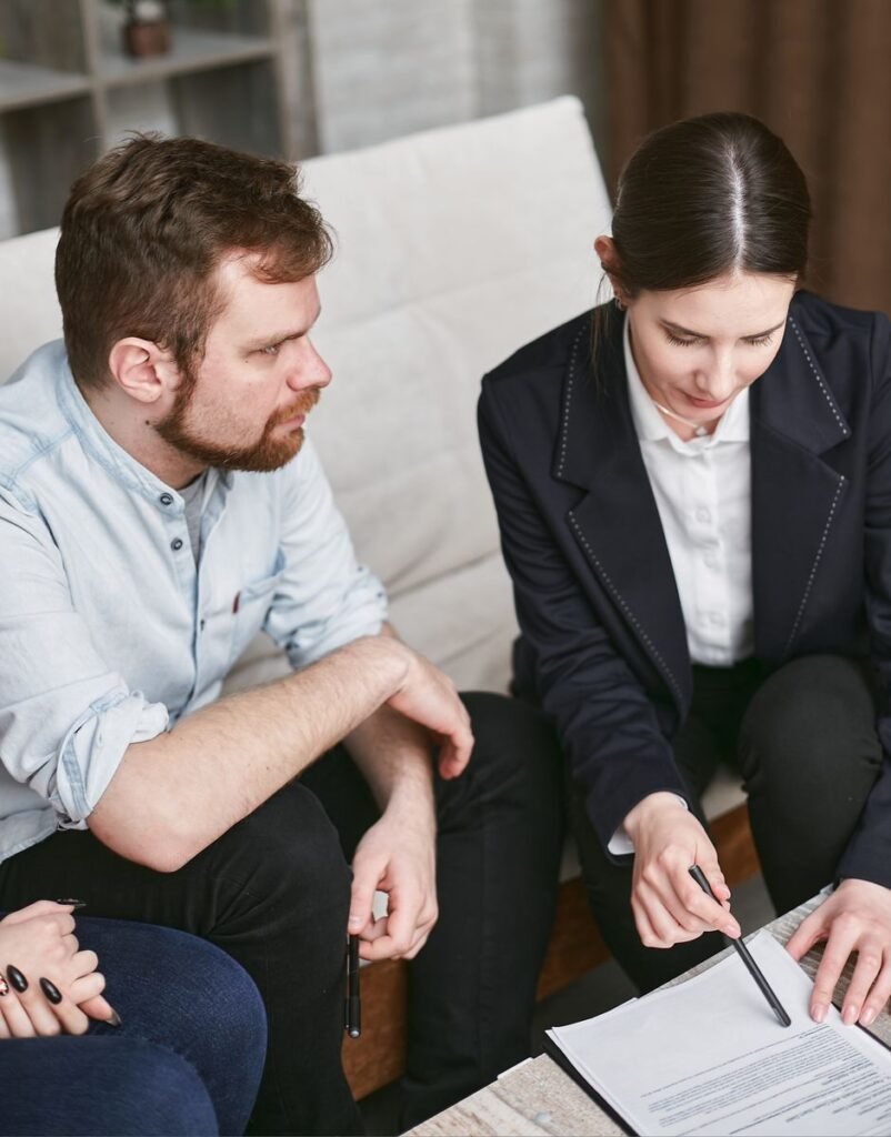 Mortgage advisor in a business suit reviewing a salary transfer and mortgage document with a client