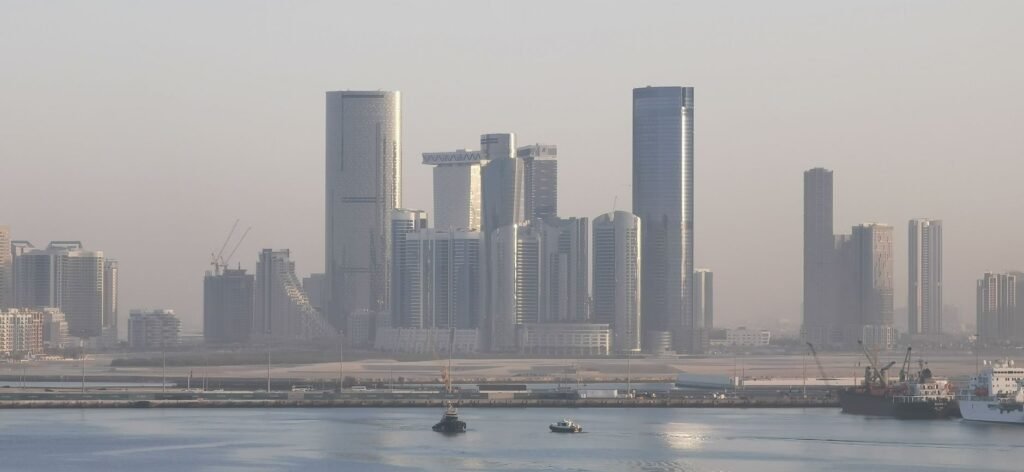 Abu Dhabi skyline with modern residential towers and a tower crane on a building under construction, illustrating off-plan mortgage financing during the construction phase