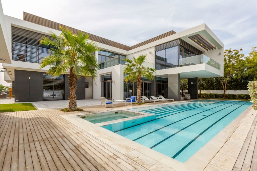 Modern two-storey villa in Dubai with a long swimming pool, wooden deck and palm trees, the kind of second home a buyer finances at 60% loan-to-value